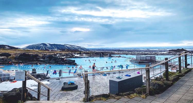 Des baigneurs se détendent dans les eaux turquoise fumantes du Blue Lagoon d'Islande, entourées de champs de lave.