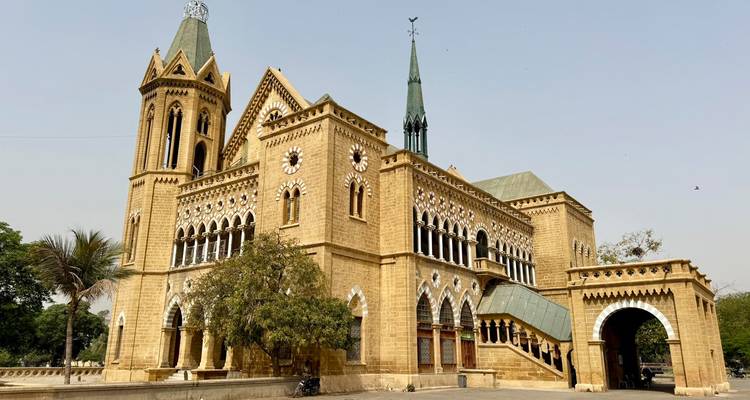 Le Frere Hall néo-gothique à Karachi avec ses flèches pointues, ses arches et sa pierre de couleur sable sous un ciel brumeux.