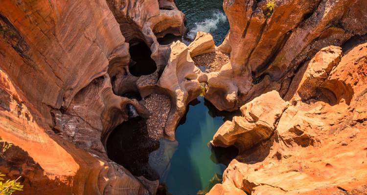 Pozas de arenisca erosionada y piscinas esmeralda vistas desde arriba en paisaje de cañón