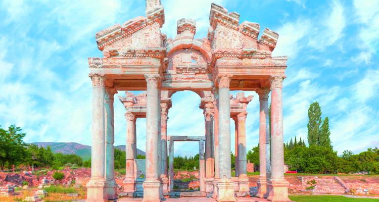 Gut erhaltenes marmornes Tetrapylon-Tor von Aphrodisias vor einem strahlend blauen Himmel stehend.
