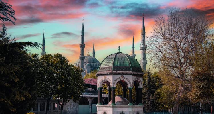 Sonnenuntergangstöne über Istanbuls Deutschem Brunnen mit den Minaretten der Blauen Moschee, die in den farbenprächtigen Himmel ragen.