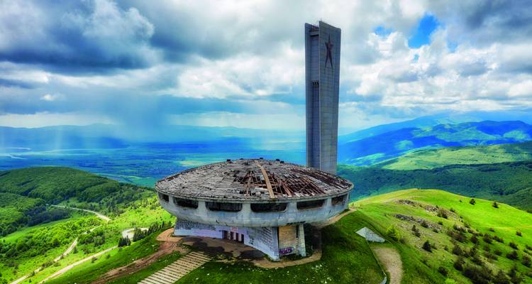 Futuristisches verlassenes Buzludzha-Denkmal und hoher Turm auf sanften grünen Hügeln