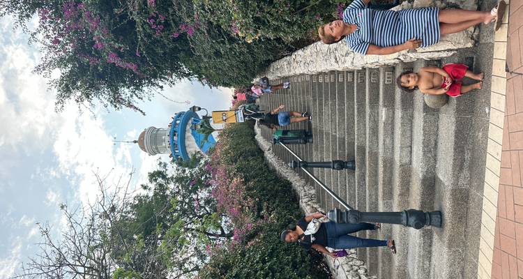 Les visiteurs montent l'escalier coloré vers le phare de Guayaquil sur la colline Santa Ana entourée de bougainvilliers.