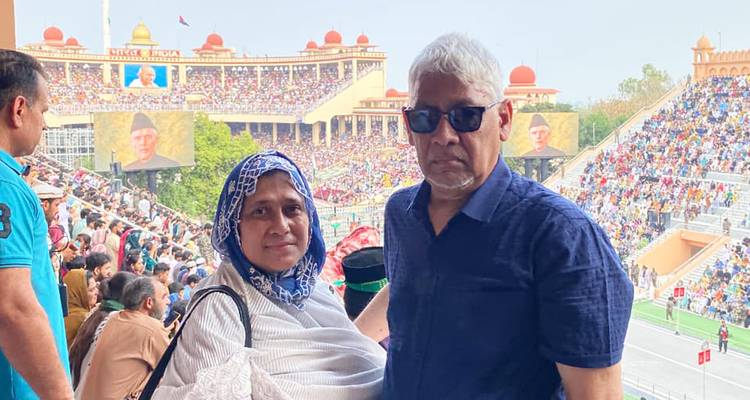 Couple watches colourful military ceremony from packed grandstands at Wagah border.