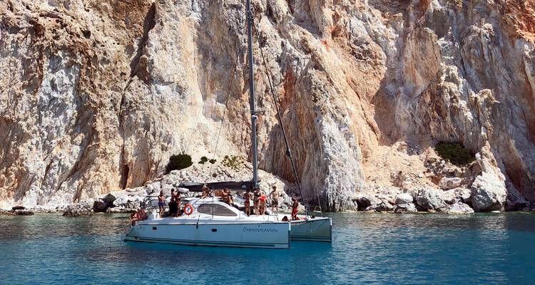 Image en double : catamaran avec touristes ancré près de falaises colorées et eau claire