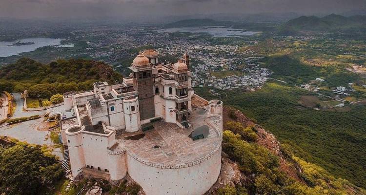 Luchtfoto van Monsoon Palace gelegen op een heuvel boven de stad Udaipur en meren.