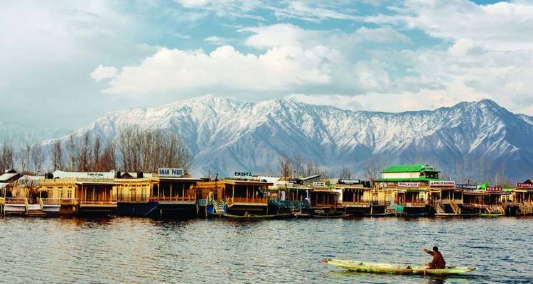 Reihe von Srinagar-Hausbooten auf dem Dal-See mit schneebedeckten Bergen im Hintergrund.