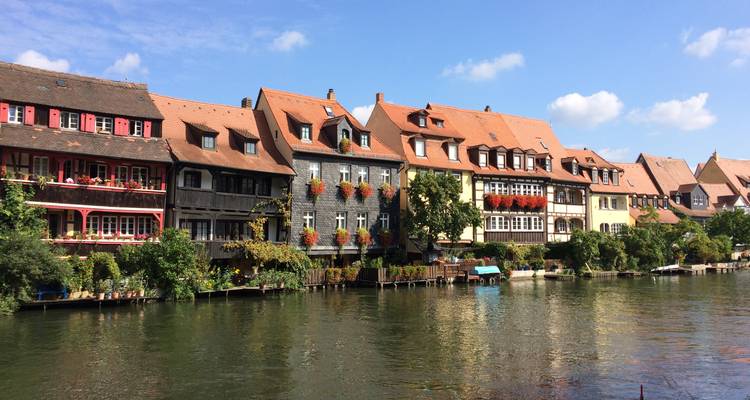 Rij kleurrijke huizen aan de rivier weerspiegeld in het rustige water van de Regnitz rivier in Bamberg.