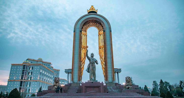 Cliché crépusculaire du monument d'Ismaïl Samani illuminé avec un ciel aux teintes bleues.
