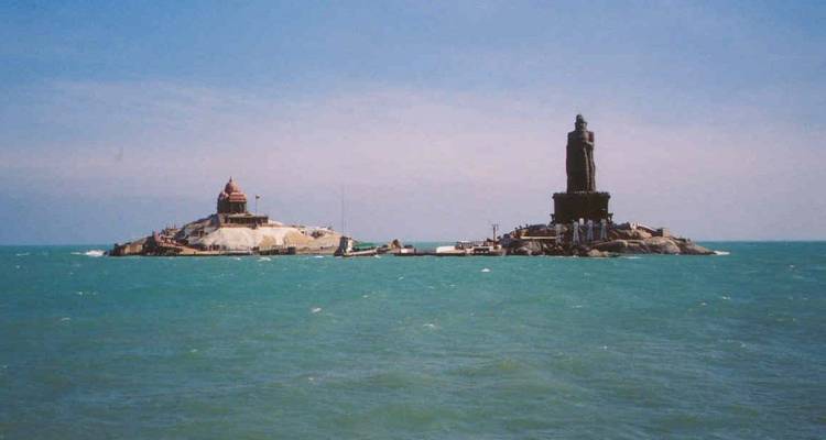 Vue lointaine du Mémorial du Rocher Vivekananda et de la Statue de Thiruvalluvar dressées sur des îlots rocheux jumeaux dans une mer bleu-vert.