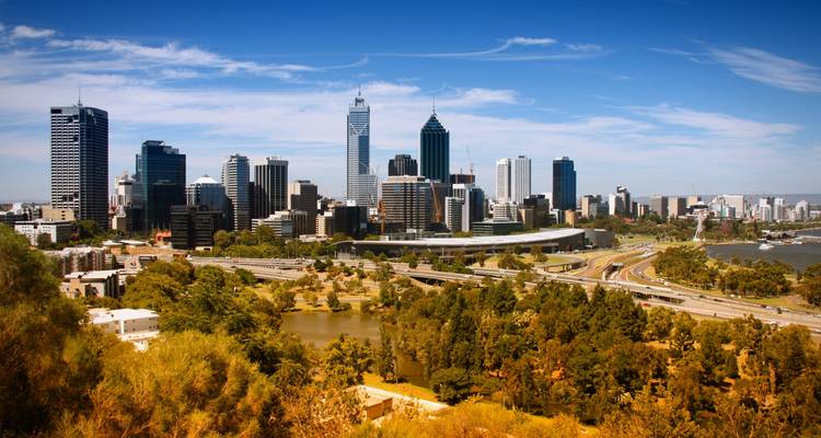 Panorama de ciel bleu dégagé de l'horizon de Perth s'élevant au-dessus de la rivière Swan et de la verdure luxuriante de Kings Park.
