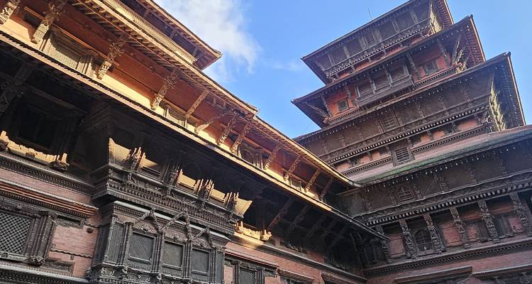 Kunstvoll geschnitzte Palastgebäude aus Ziegel und Holz, die sich zu einem strahlend blauen Himmel erheben.