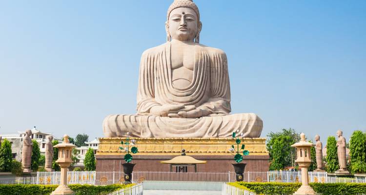 Vue de face de la statue de Bouddha assis de Bodhgaya baignée dans la lumière vive du soleil.