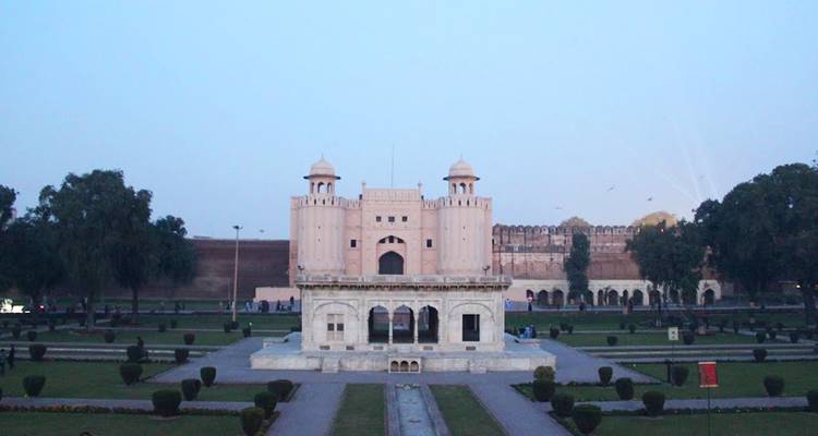 Vue symétrique de la porte Alamgiri et des jardins entretenus du fort de Lahore pendant l'heure bleue