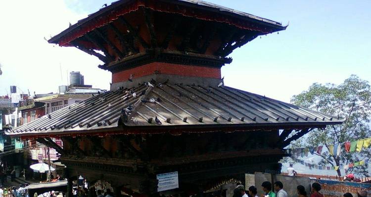 Templo pagoda de ladrillo y madera bullicioso de palomas y devotos