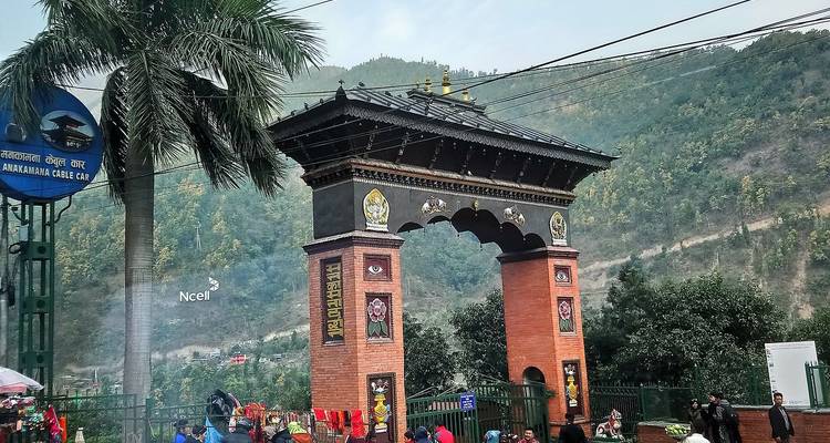 Arco de entrada decorativo de ladrillo adornado with tallados y visitantes pasando por debajo