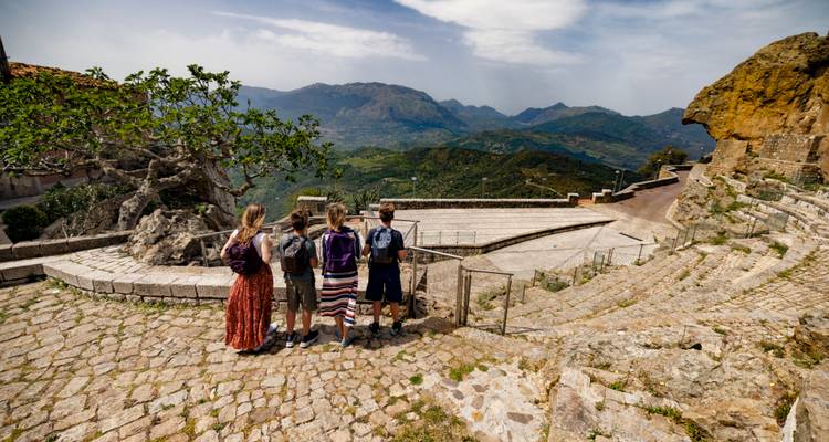 Kleine Gruppe mit Blick auf ein antikes Amphitheater und weite Bergpanoramen dahinter