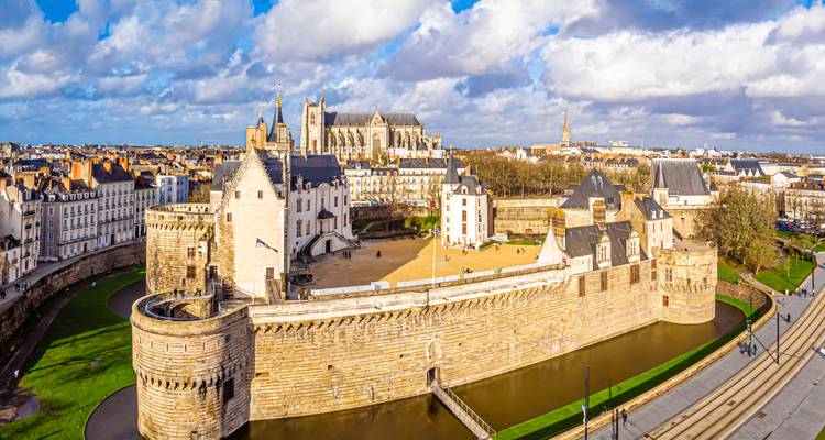 Panorama-Luftaufnahme des Château des Ducs de Bretagne und der Kathedrale von Nantes unter dramatischen Wolken