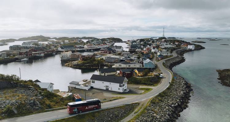 Luftaufnahme eines Küstenfischerdorfs, das durch eine geschwungene Straße verbunden und von kleinen Inseln umgeben ist