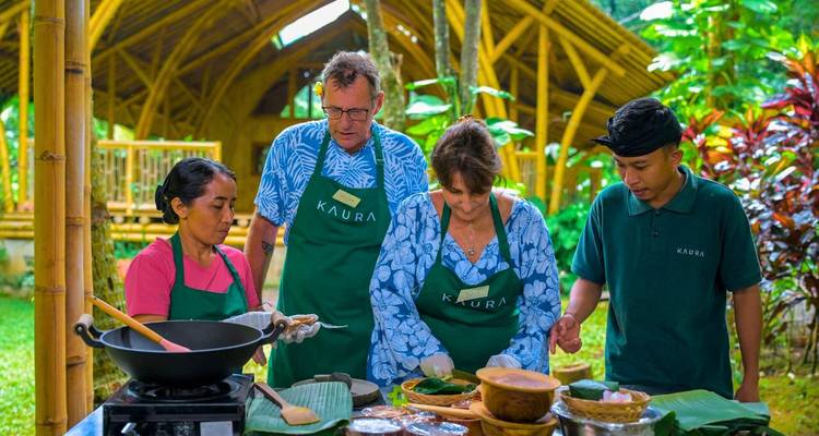 Kleine groep in schorten bereidt traditionele gerechten tijdens een Balinese kookles buiten.