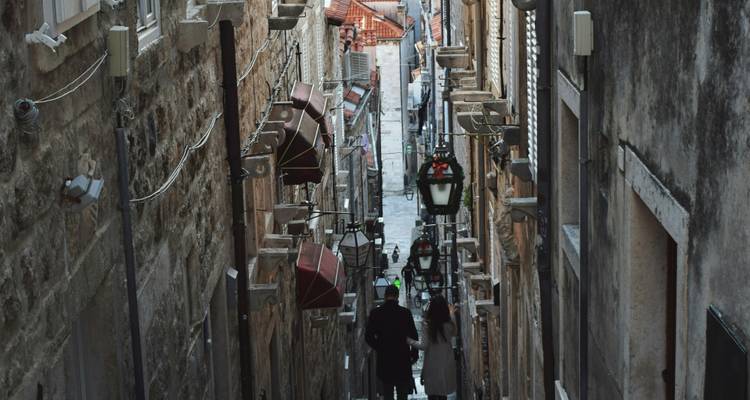 Callejón empinado y estrecho con faroles colgantes y muros de piedra en el casco antiguo de Dubrovnik