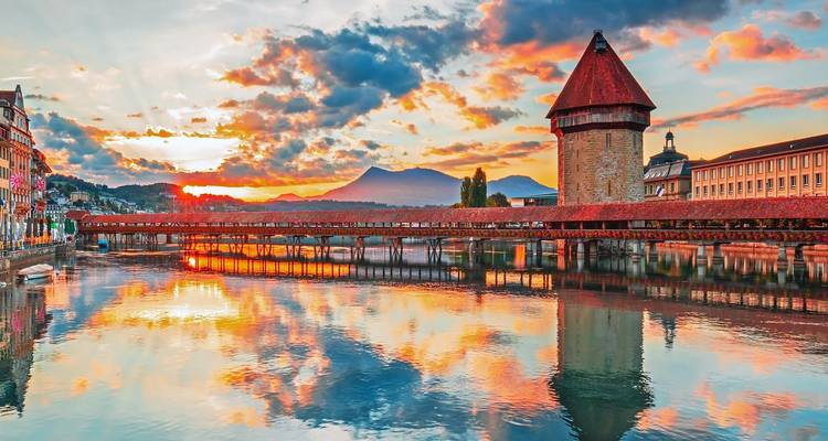 Zonsopkomstreflecties van de Kapelbrug en Watertoren op de rivier de Reuss in Luzern.