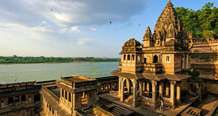 Elegant rivieroever tempelcomplex met uitzicht op de Narmada rivier onder dramatische wolken