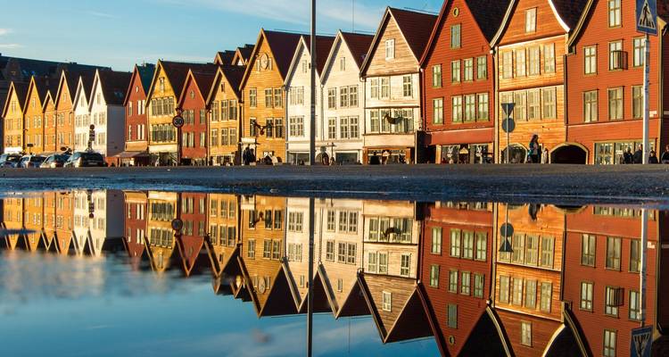 Historic wooden Hanseatic wharf houses in Bergen reflected perfectly in a rain puddle