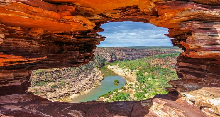 Vue panoramique à travers une arche naturelle de grès sur une gorge fluviale en contrebas