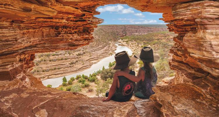 Deux enfants portant des chapeaux sont assis dans une fenêtre de grès donnant sur une vallée de lit de rivière asséché