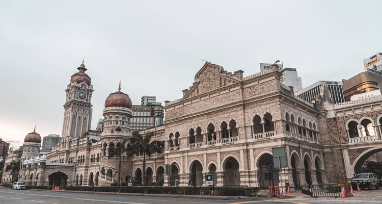 Historisches Sultan Abdul Samad Gebäude mit Mogul-Architektur entlang einer ruhigen Stadtstraße im Morgengrauen.