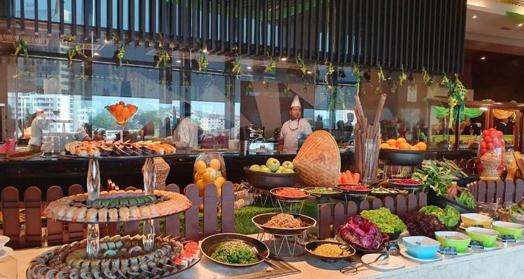 Abundante buffet con frutas, mariscos y verduras, con chefs trabajando detrás del mostrador.