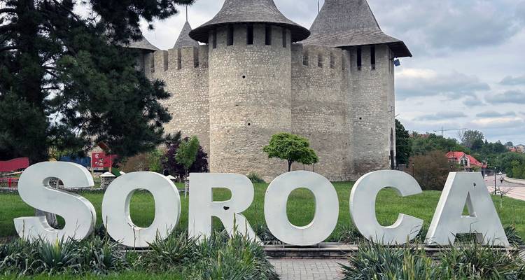 Grandes letras blancas que deletrean SOROCA frente a torres de fortaleza medieval de piedra