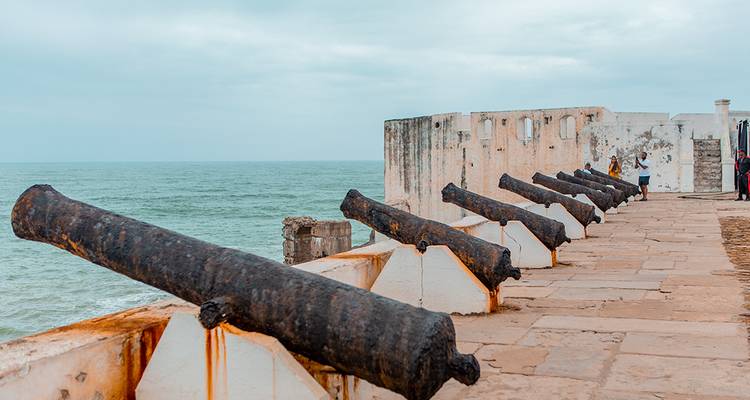 Historische rij kanonnen die uitkijken over de Atlantische Oceaan vanaf een witgekalkte kustfortmuur.