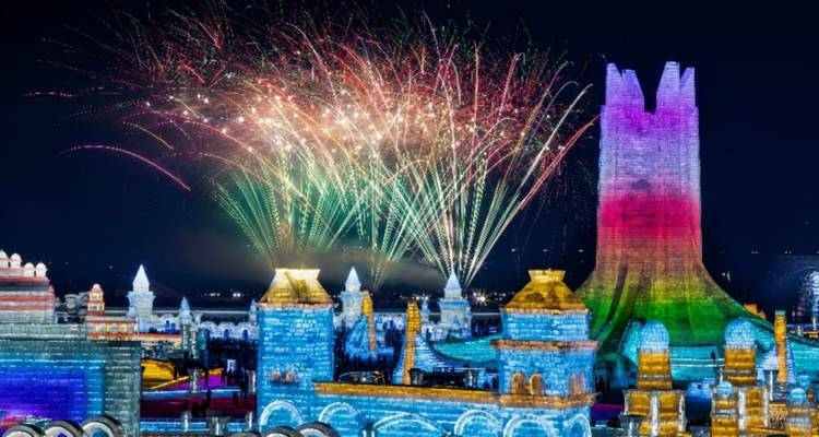Nighttime fireworks burst over brightly lit ice sculptures at Harbin Ice Festival