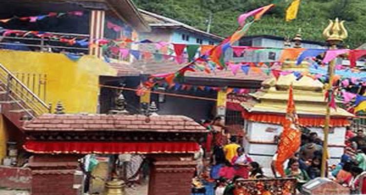 Colorful village temple festival scene with flags and crowds, low image clarity.