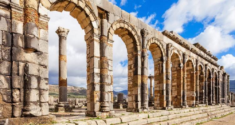 Close view of intact stone arches and columns of the Volubilis archaeological site.