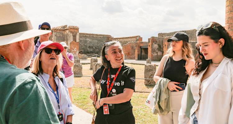 Guía local que involucra a un pequeño grupo de turistas entre las ruinas antiguas de Pompeya.