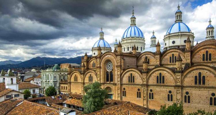 Vista dramática de la Nueva Catedral de Cuenca con cúpulas azules bajo un cielo tormentoso.