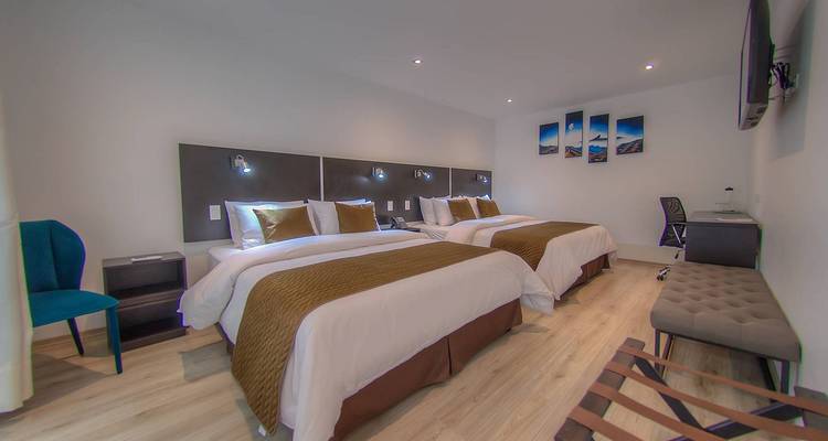 Habitación de hotel moderna con dos camas grandes, decoración neutra e iluminación ambiental