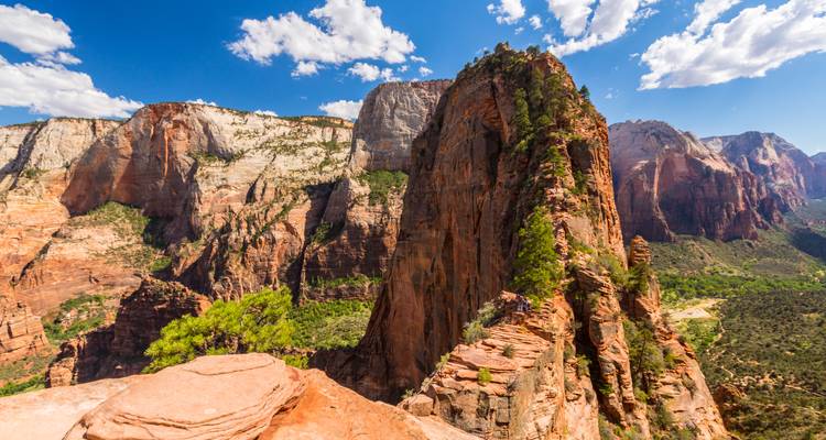 Towering sandstone cliffs and rugged peaks bathed in bright sunlight at Zion National Park.
