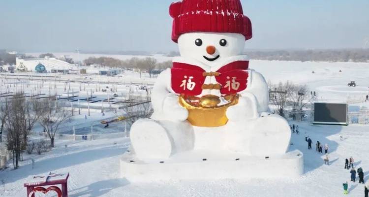 A massive snowman statue wearing a red hat overlooks a snowy park with small visitors below.