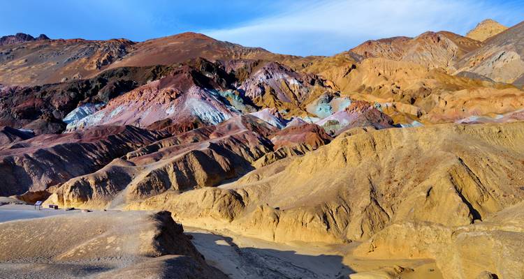 Levendig gekleurde heuvels en badlands bekend als Artist's Palette onder een blauwe hemel.