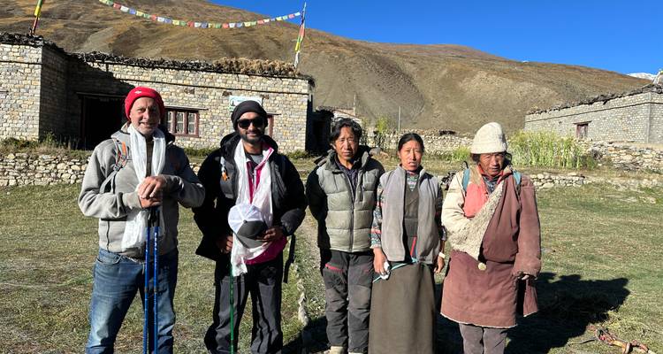 Trekkinggids en lokale dorpelingen poseren samen in een hooggelegen Himalaya-gehucht.