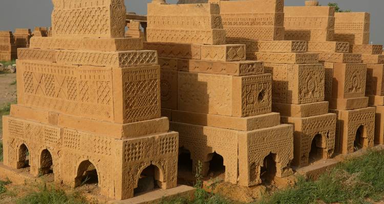 Detailed view of patterned sandstone graves with small arches at their bases