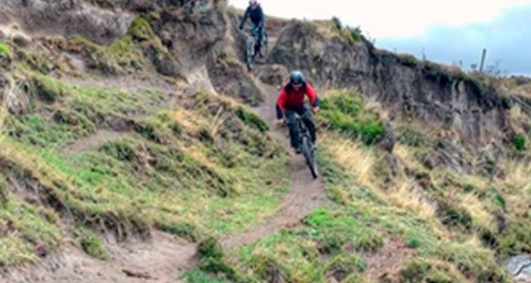 Unscharfe Actionaufnahme von Mountainbikern, die einen zerklüfteten Hochlandweg hinabfahren