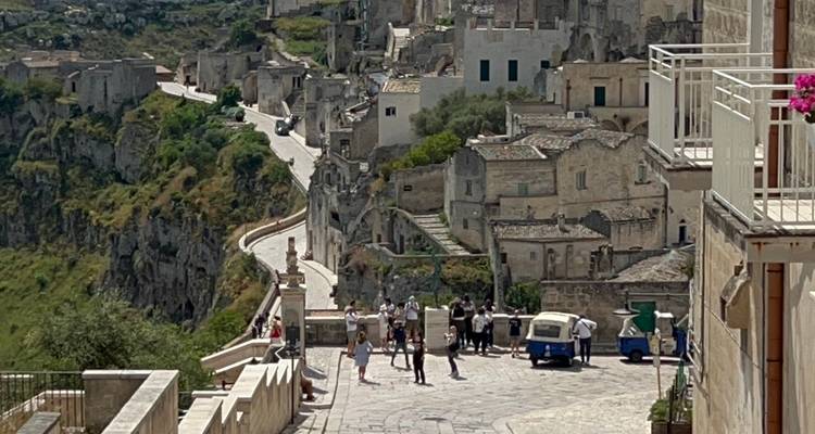 Vue surélevée d'habitations en pierre perchées sur des falaises avec une route sinueuse en contrebas à Matera.