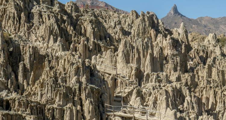Formations de calcaire gris déchiquetées et passerelles en bois d'une vallée érodée spectaculaire sous un ciel bleu clair