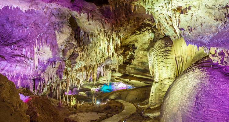 Las estalactitas iluminadas y la iluminación colorida crean una escena surrealista dentro de la Cueva de Prometeo.