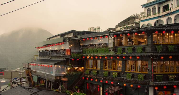 Maisons de thé brumeuses à flanc de colline de Jiufen illuminées de lanternes rouges par un soir pluvieux